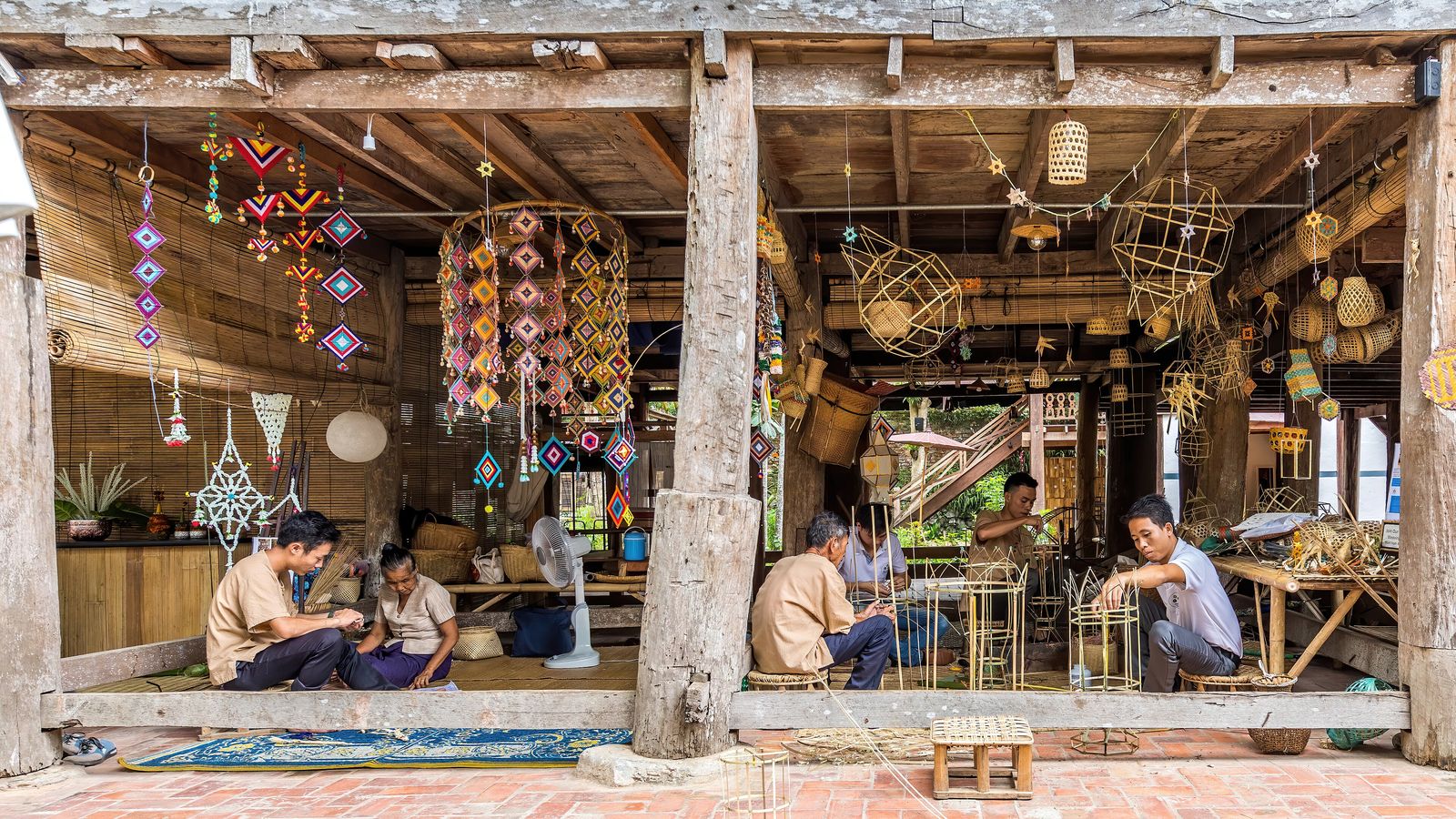 A craftsperson weaving bamboo inside a heritage house in Luang Prabang, Laos