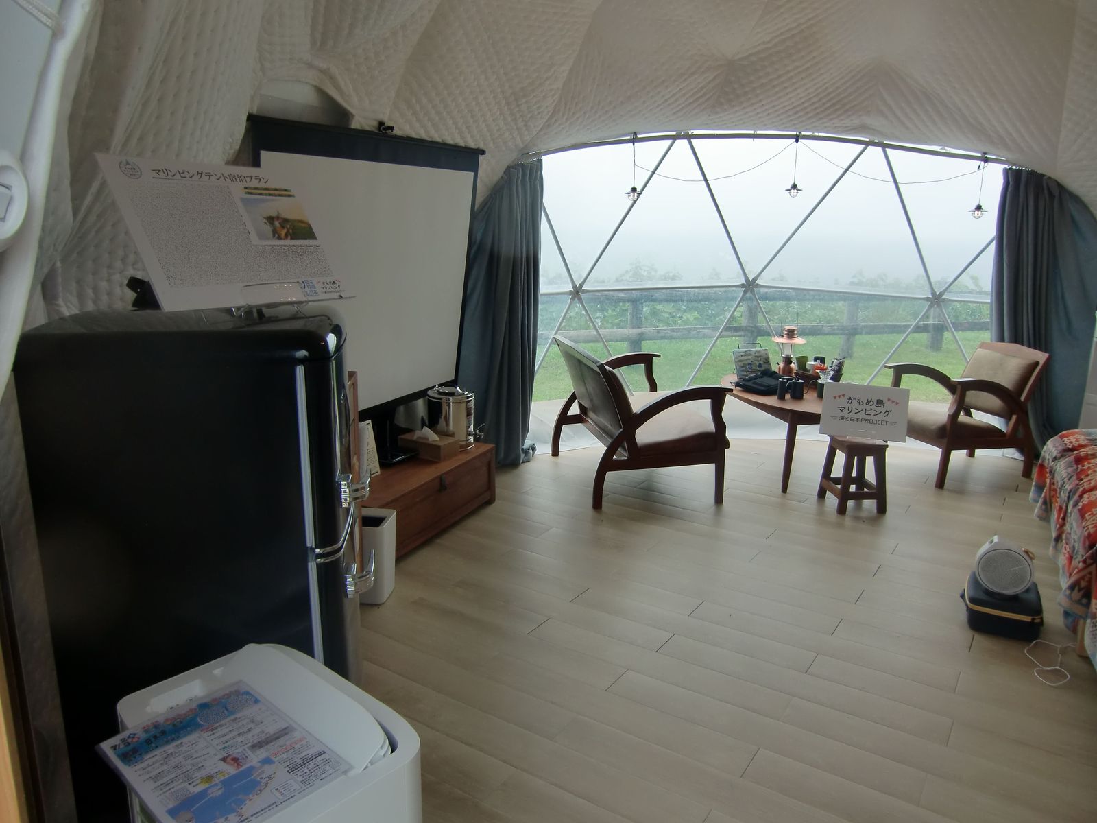 A glamping dome tent set up in a tropical garden with jungle plants around it