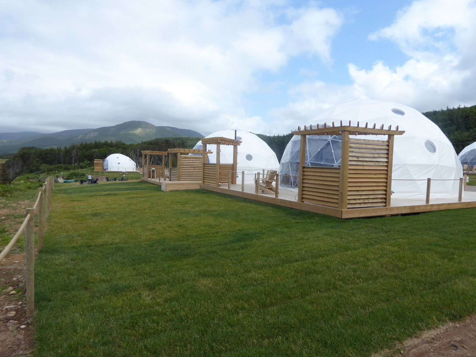 Geodesic dome guest structures with a forest and mountain backdrop