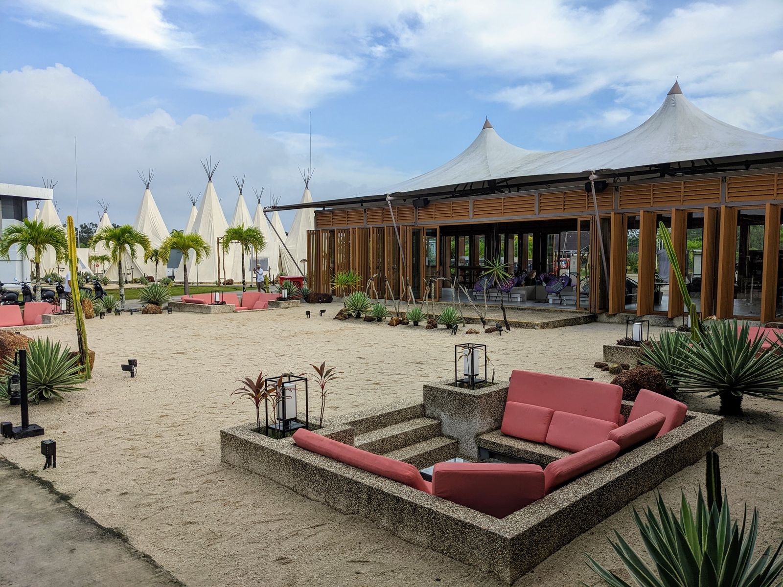 Canvas tent structures and palm trees at a tropical glamping resort