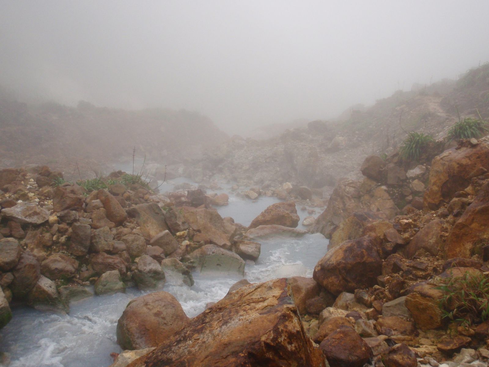 The Boiling Lake in Dominica, a flooded fumarole with steam rising from its grey-blue water inside Morne Trois Pitons National Park
